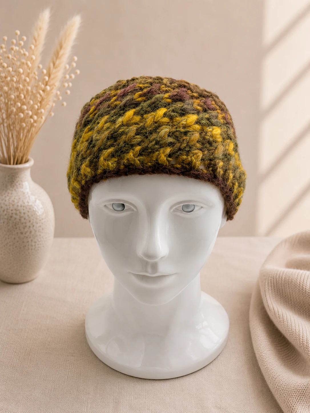 Handgestricktes Stirnband, Modell HM-03, auf einer Produktpräsentation.