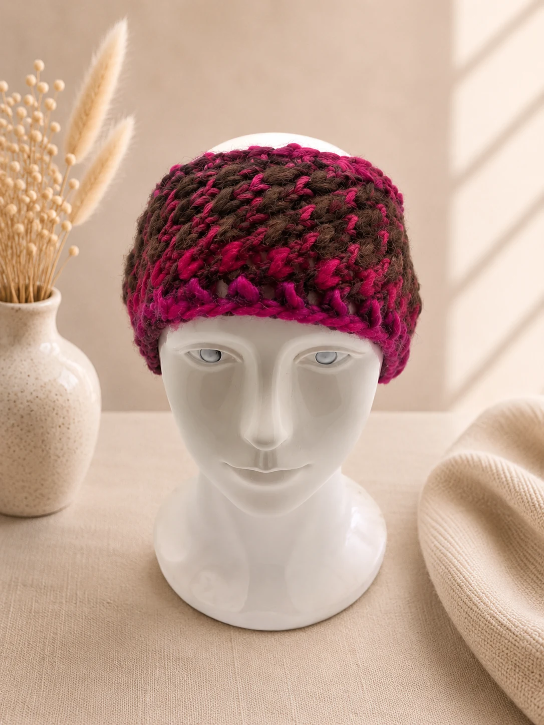 Handgestricktes Stirnband, Modell HM-05, auf einer Produktpräsentation.