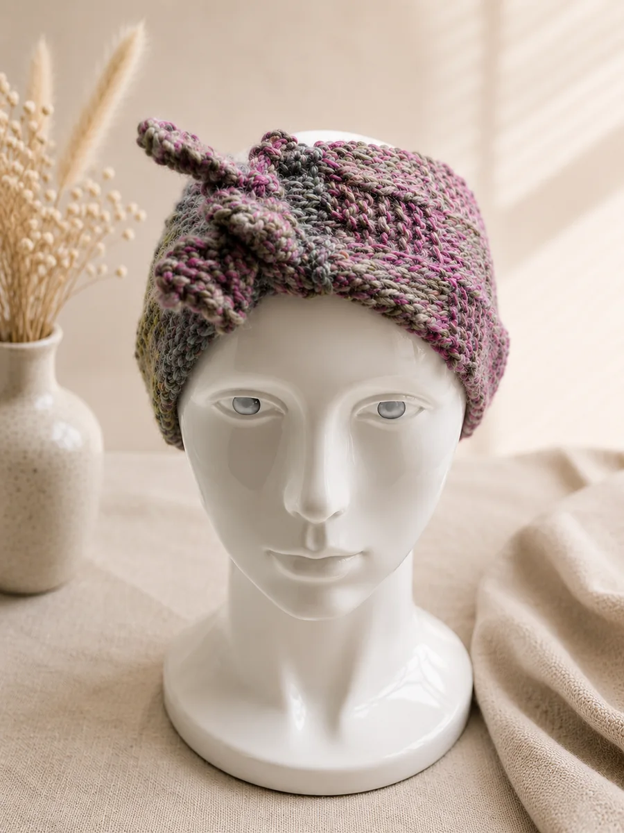 Handgestricktes Stirnband, Modell GB-13, auf einer Produktpräsentation.