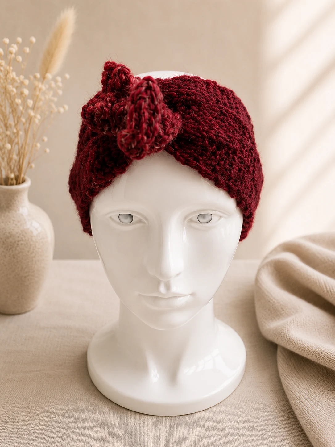 Handgestricktes Stirnband, Modell GB-08, auf einer Produktpräsentation.