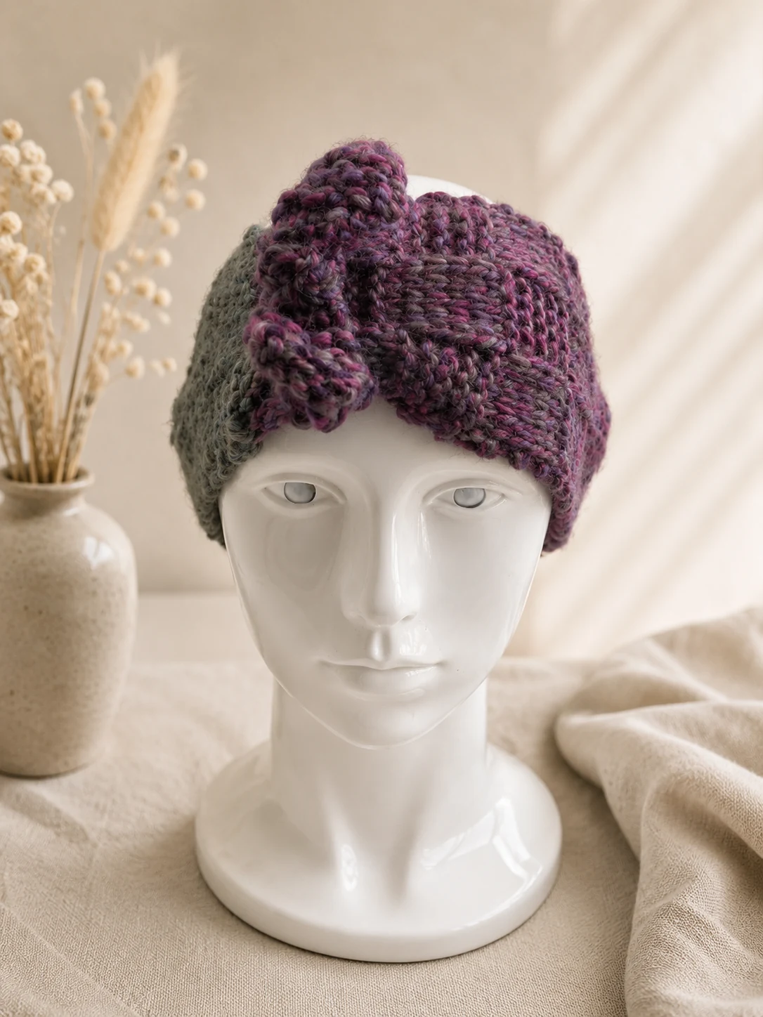Handgestricktes Stirnband, Modell GB-09, auf einer Produktpräsentation.