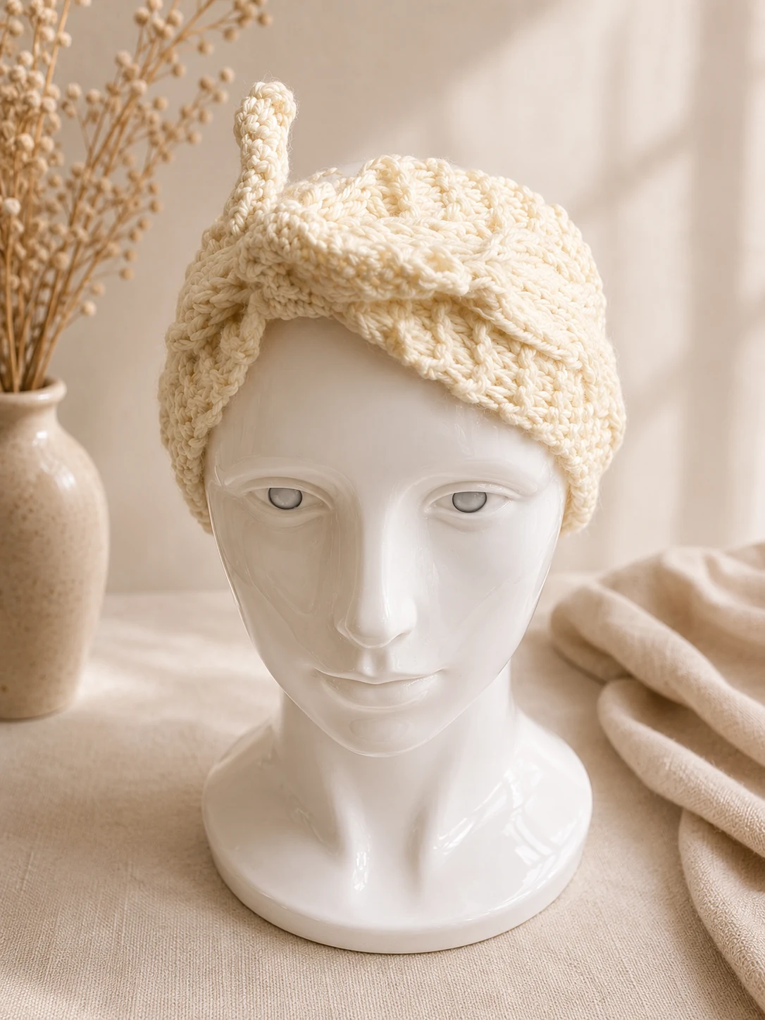 Handgestricktes Stirnband, Modell GB-12, auf einer Produktpräsentation.