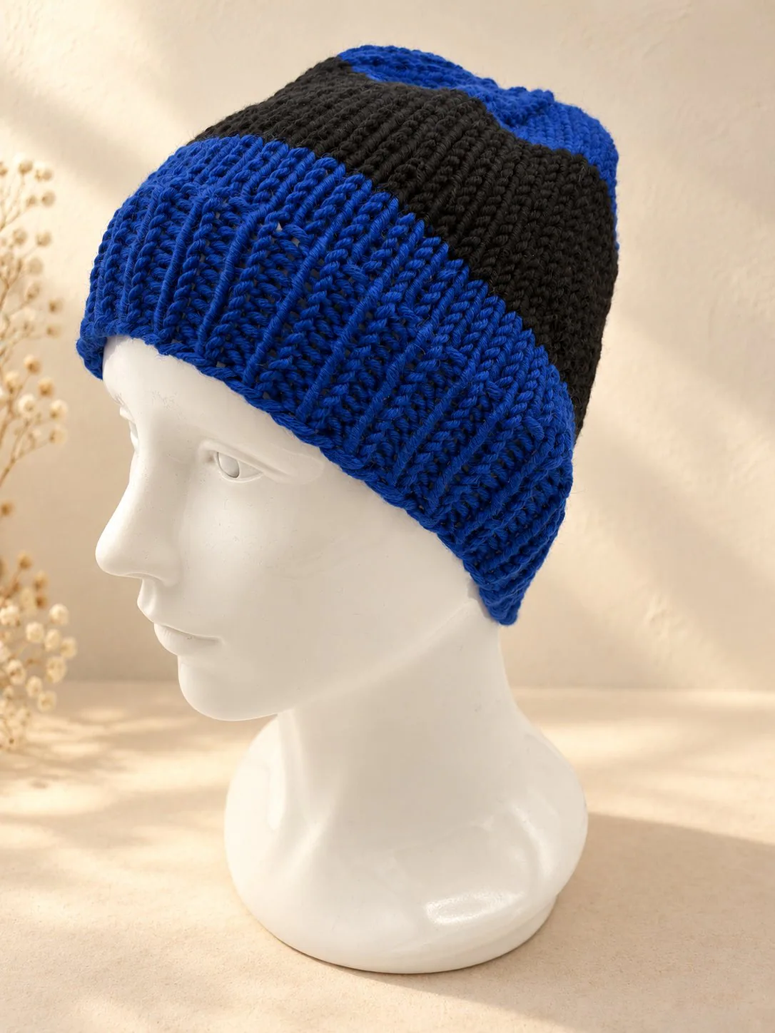 Handgestrickte Mütze in Blau und Schwarz, Produktfoto.