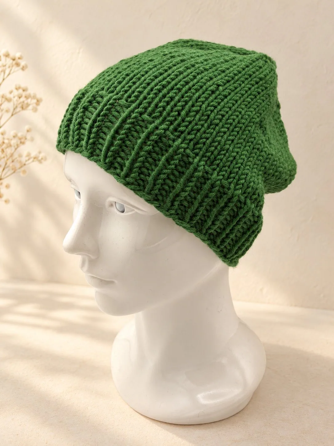 Handgestrickte Mütze in Dunkelgrün, Produktfoto.