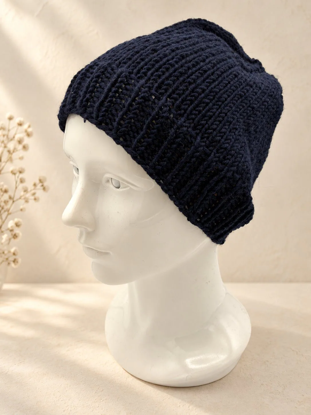 Handgestrickte Mütze in Marineblau, Produktfoto.