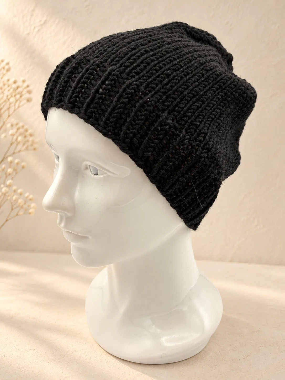 Handgestrickte Mütze in Schwarz, Produktfoto.