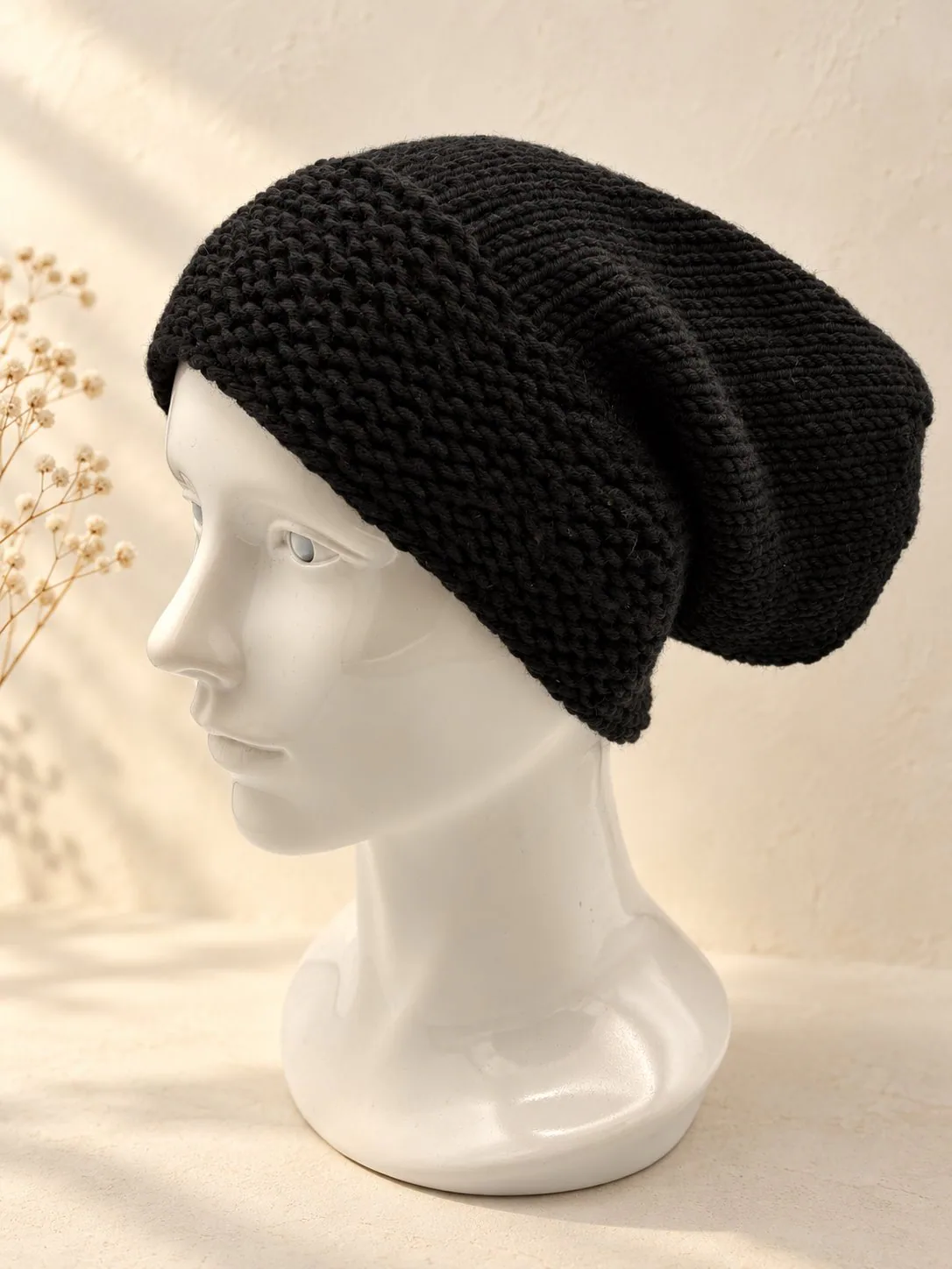 Handgestrickte Slouchmütze in Schwarz, Produktfoto.